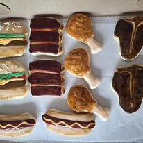 Decorated sugar cookies shaped like steaks, hot dogs and chicken legs