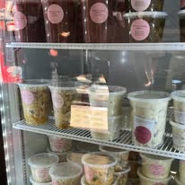 Refrigerated deli case filled with labeled salads and sides