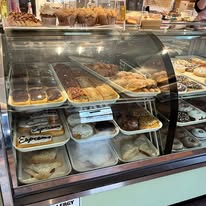 Full bakery display case of doughnuts, pastries and desserts