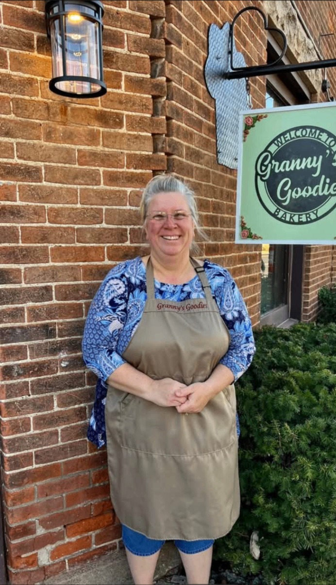 Granny standing in her apron outside the Granny's Goodies Bakery storefront in Mulberry, Indiana