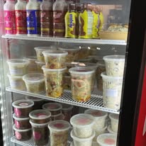 Cooler with bottled drinks, snacks and containers of homemade salads
