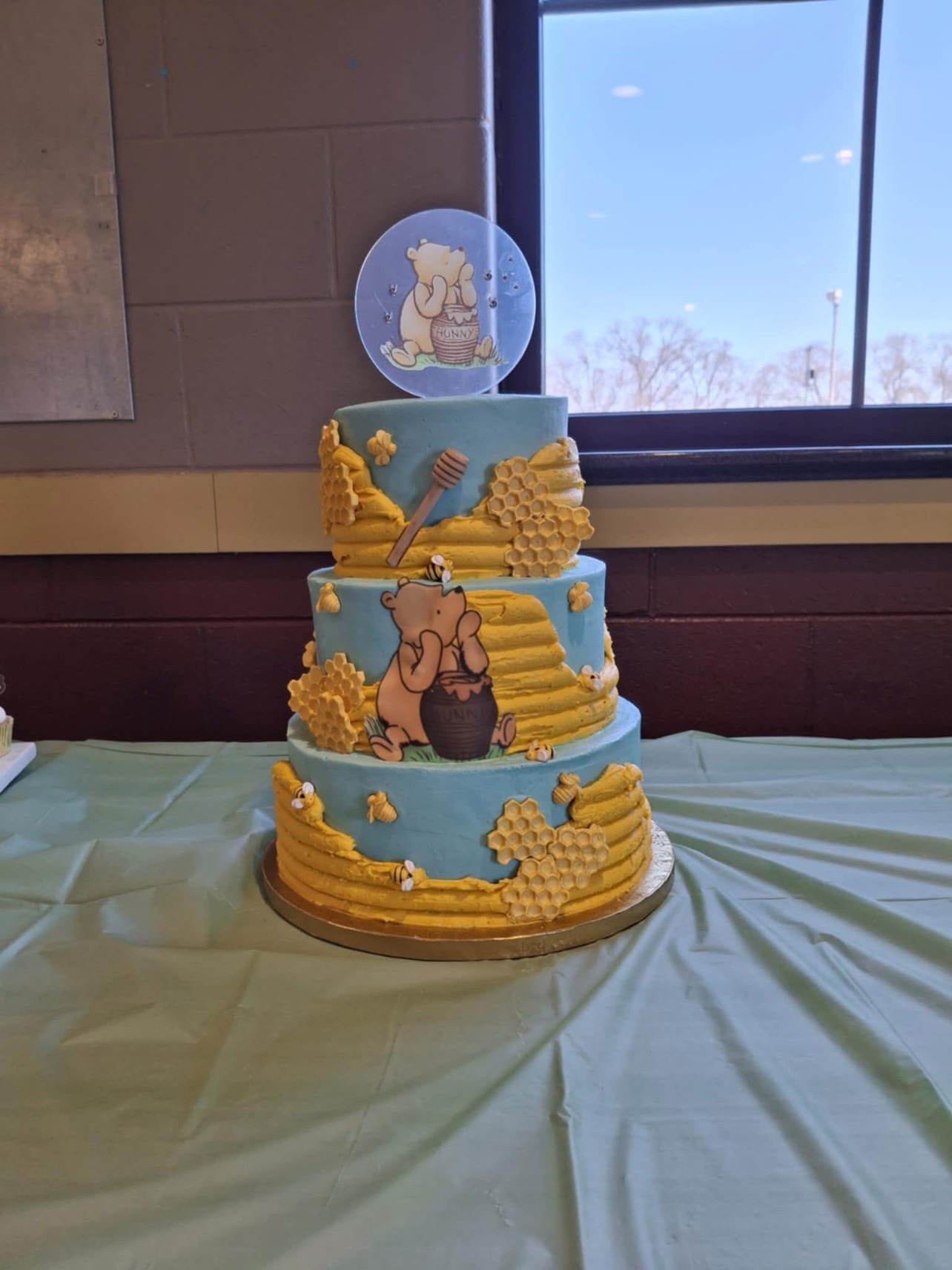 Three-tier baby blue honeycomb cake with a honey bear and bees