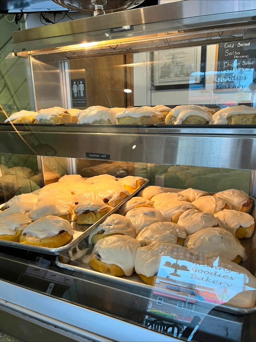 Trays of glazed cinnamon rolls in the warm case at Granny's Goodies Bakery