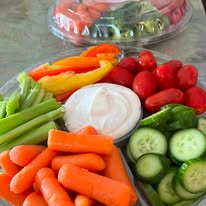 Fresh vegetable tray with peppers, carrots, celery, cucumbers and dip