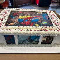 Sheet cake with a comic book photo print topper and red and white sprinkle border