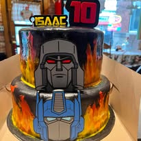 Two-tier cake airbrushed with flames and hand-painted robot faces